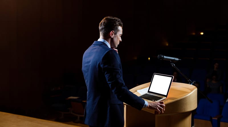 Man giving speec in blue coat